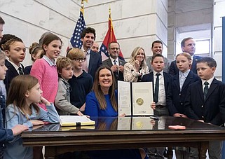 La gobernadora de Arkansas, Sarah H. Sanders, muestra su firma dentro del Proyecto de Ley LEARNS Act, desde su oficina en Little Rock. Foto: Twitter / @SarahHuckabee.